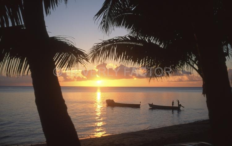 island;kadavu island fiji;sky;sunset;clouds;blue water;sun;yellow;water;boat;palm trees;sillouettes;blue;anchorages;ocean